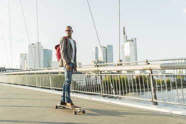 Germany, Frankfurt, man skateboarding on bridge - UUF004045
