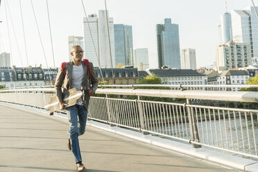 Germany, Frankfurt, man running with skateboard on bridge - UUF004047