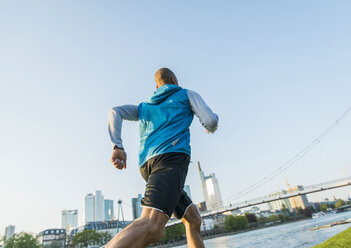 Deutschland, Frankfurt, Mann beim Joggen am Flussufer - UUF004050