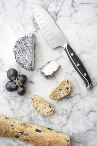 Ziegenkäse, Brot und Obst auf Carerra-Marmor-Hintergrund, lizenzfreies Stockfoto
