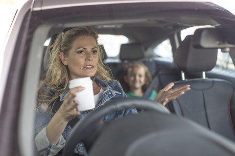 Serious woman and girl in car stock photo