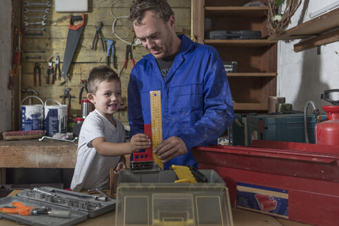 Father and son working in home garage - ZEF004819
