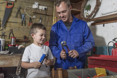 Father and son working in home garage - ZEF004820