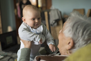 Baby boy smiling to an elderly woman at home - RAEF000163