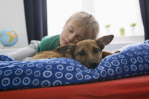Junge und Hund auf dem Bett liegend - PDF000916