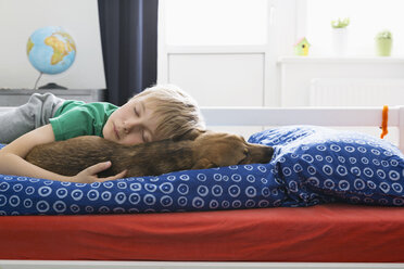 Boy and dog lying on bed - PDF000919