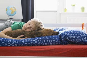 Junge und Hund auf dem Bett liegend - PDF000919
