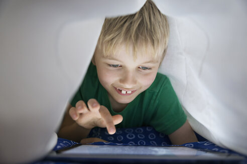 Junge mit digitalem Tablet im Bett unter der Decke - PDF000931