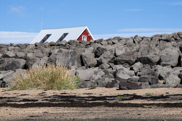 Iceland, Stokkseyri, house hidden behind stone wall - KEBF000166