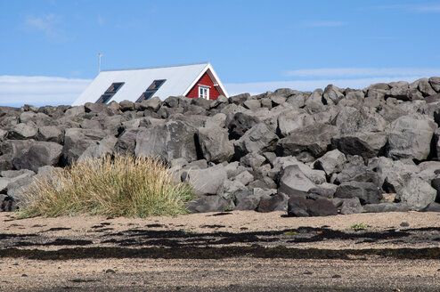 Island, Stokkseyri, Haus hinter Steinmauer versteckt - KEBF000166