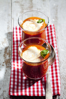 Zwei Gläser Tomatensuppe garniert mit Sahne und Basilikumblatt - CSF025409