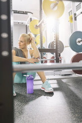 Junge Frau entspannt sich nach dem Training im Fitnessstudio - MADF000203