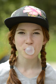 Porträt eines Mädchens mit Kaugummiblase und Mütze - LBF001115