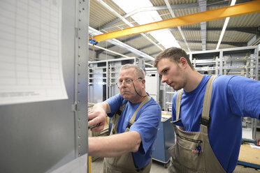 Zwei Arbeiter in einer Fabrik für Schaltanlagenbau - LYF000408