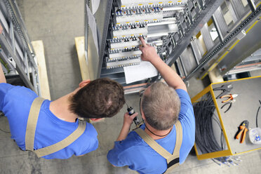 Two workers in a switchboard construction factory - LYF000417