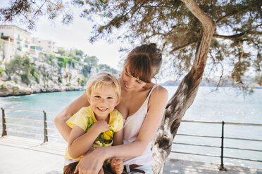 Spanien, Mallorca, Porto Christo, kleiner Sohn sitzt auf dem Schoß seiner Mutter - MFF001586