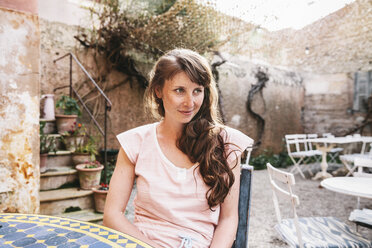 Spanien, Mallorca, Arta, Porträt einer Frau, die im Innenhof eines Cafés sitzt - MFF001597