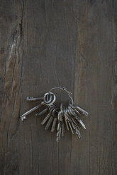 Ein alter Schlüsselbund auf dunklem Holz - CRF002684