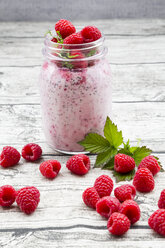 Raspberries, chia, milk, kiwi, hemp seed and mint in a glass - LVF003318