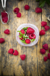 Raspberries, chia, milk, kiwi, hemp seed and mint in a glass - LVF003321