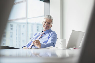 Businessman sitting at desk - RBF002682