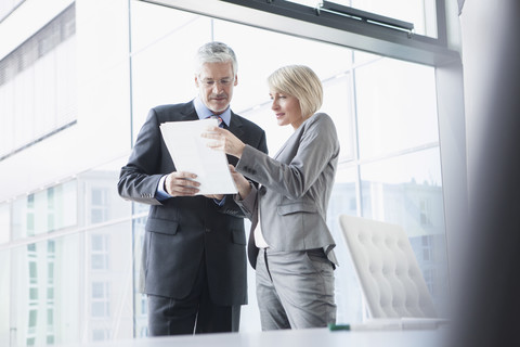 Businissman and businesswoman discussing documents stock photo