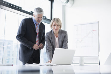 Businissman and businesswoman preparing for presentation - RBF002702