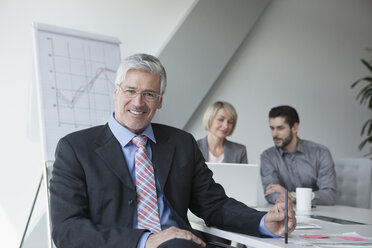 Businessman in meeting listening to presentation - RBF002708