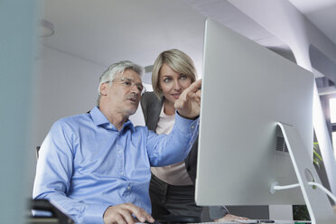 Businesspeople discussing work at computer - RBF002726