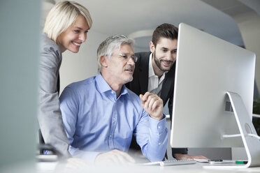 Businesspeople discussing work at computer - RBF002729