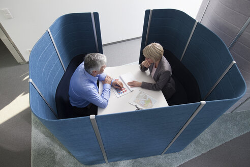 Geschäftsmann und Geschäftsfrau arbeiten in einem abgetrennten Sitzungssaal - RBF002731