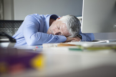 Businessman sitting at desk, sleeping - RBF002741