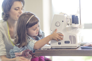 Mother and daughter sewing clothes at home - ZEF004833