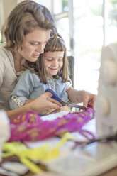 Mother and daughter making clothes at home - ZEF004836