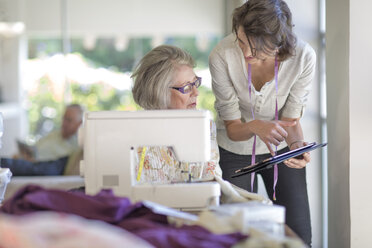 Senior woman and adult daughter working on sewing machine - ZEF004841