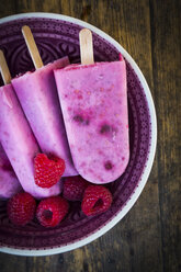 Bowl with raspberry chia ice lollies and raspberries - LVF003324