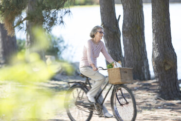 Ältere Frau fährt auf dem Fahrrad - ZEF004741