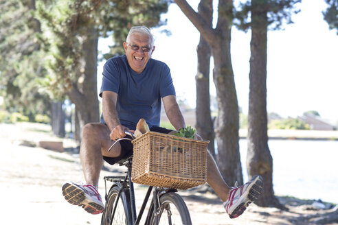 Smiling senior man balancing on bicycle - ZEF004746