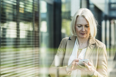 Reife Frau mit Mobiltelefon - UUF004115