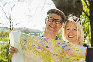 Germany, Mannheim, Mature couple taking city break, looking at map - UUF004126