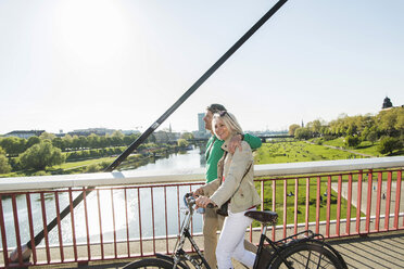 Deutschland, Mannheim, Älteres Paar überquert Brücke, schiebt Fahrrad - UUF004141