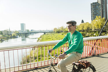 Deutschland, Mannheim, Älterer Mann radelt über Brücke - UUF004144