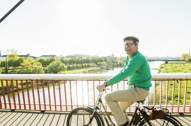 Deutschland, Mannheim, Älterer Mann radelt über Brücke - UUF004158