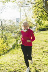 Deutschland, Mannheim, Ältere Frau joggt im Park - UUF004147