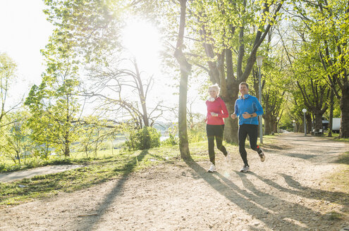 Deutschland, Mannheim, Älteres Paar joggt im Park - UUF004151
