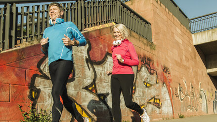 Deutschland, Mannheim, Älteres Paar beim Joggen in der Stadt - UUF004152