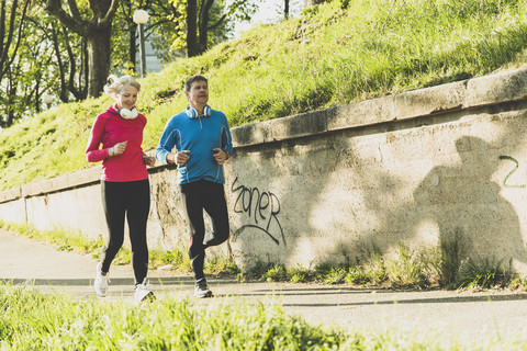 Deutschland, Mannheim, Älteres Paar beim Joggen in der Stadt, lizenzfreies Stockfoto
