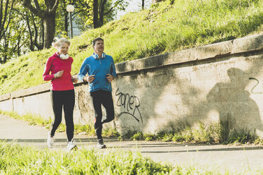 Deutschland, Mannheim, Älteres Paar beim Joggen in der Stadt - UUF004153