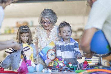 Kinder machen einen Flohmarkt, unterstützt von der Großmutter - ZEF004888