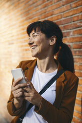 Smiling businesswoman with smartphone - EBSF000598